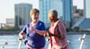 Two elderly women running on waterfront